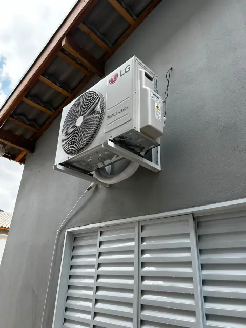 Instalação de ar-condicionado feita pela AF Ar Condicionado: Condensadora LG Dual Inverter fixada em suporte reforçado sob o beiral.