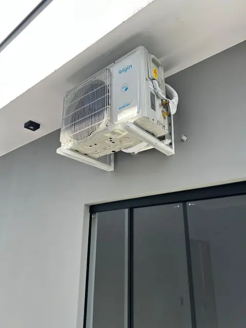 Instalação de ar-condicionado feita pela AF Ar Condicionado: Condensadora Elgin R32 Inverter em área externa, com grade de proteção.