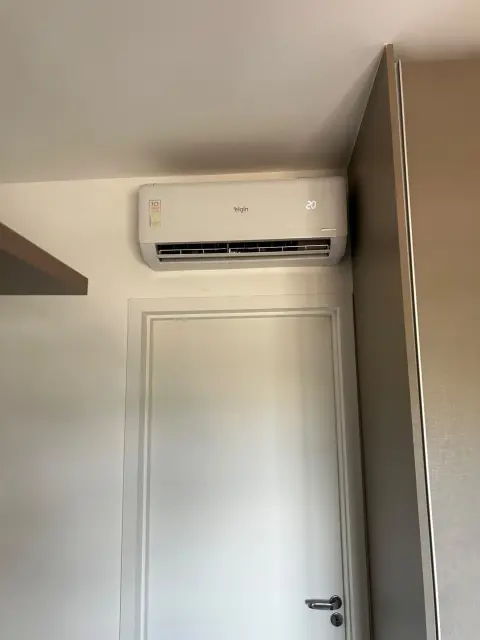 Instalação de ar-condicionado feita pela AF Ar Condicionado: Evaporadora Elgin Inverter acima da porta do quarto, alinhada no nível, operando a 20°C.